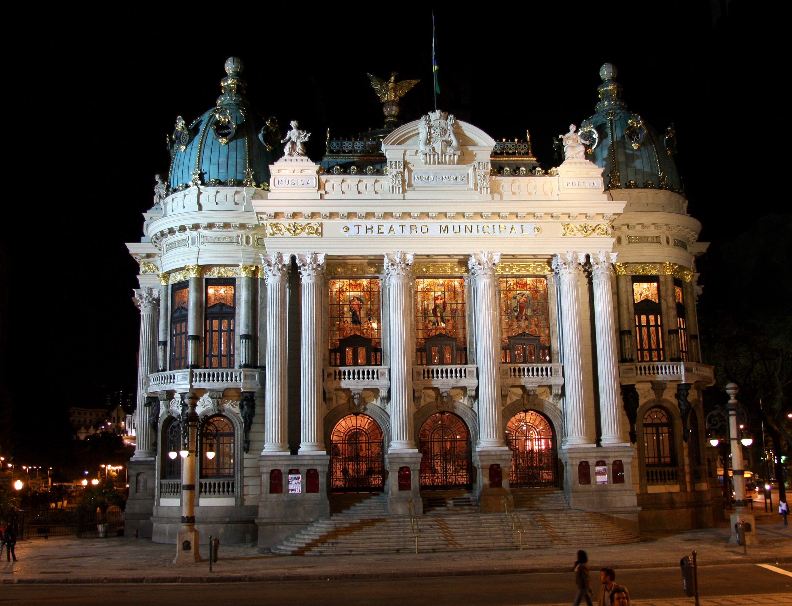 Foto da fachada noturna do Theatro Municipal. 